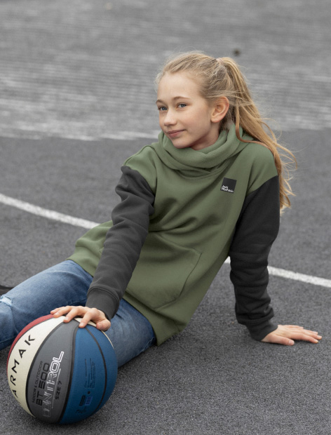 Jeune fille assise sur le sol avec un ballon de basket