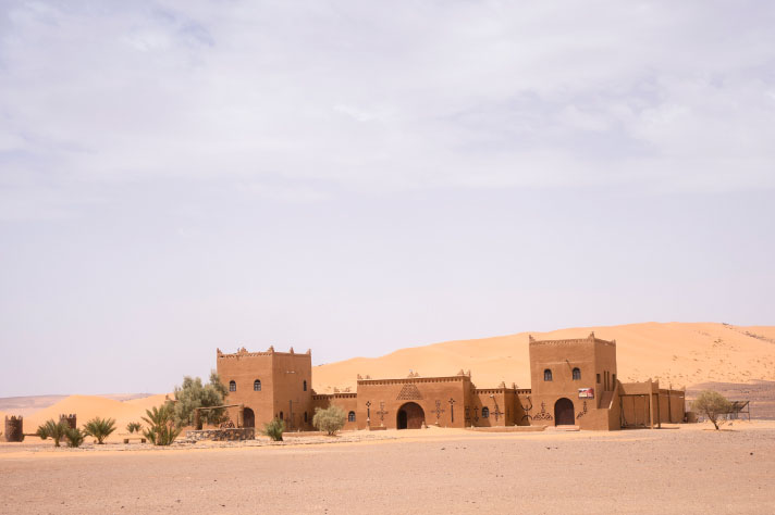 Bâtiment marron avec palmiers dans un désert