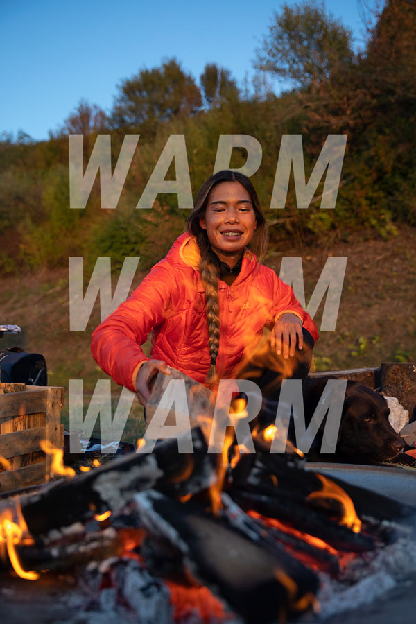 Femme au feu de camp avec une veste d'hiver