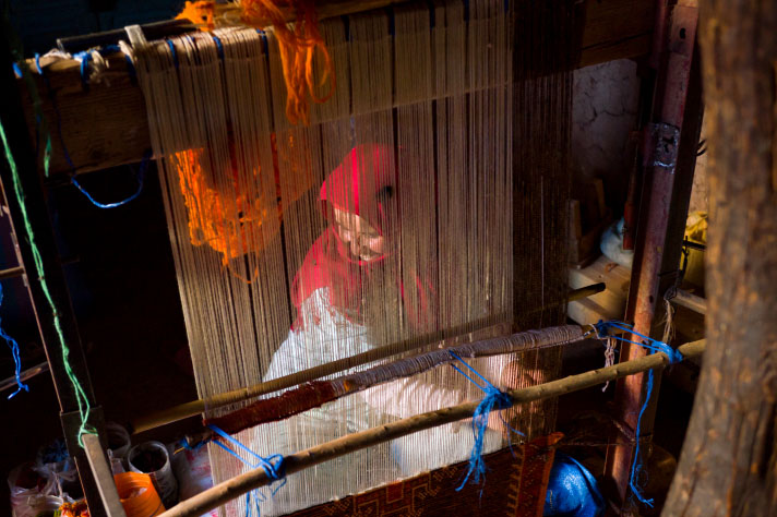 Une femme tissant un tapis