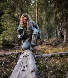 Femme sur un tronc d’arbre