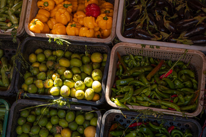 Poivrons, concombres, citrons verts et aubergines dans de grandes cagettes