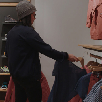 Vendeuse dans un Store avec chaussures dans le fond