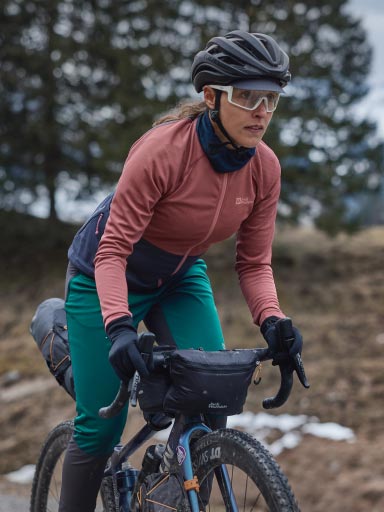 Homme avec maillot de cyclisme sortant sa gourde de la poche banane