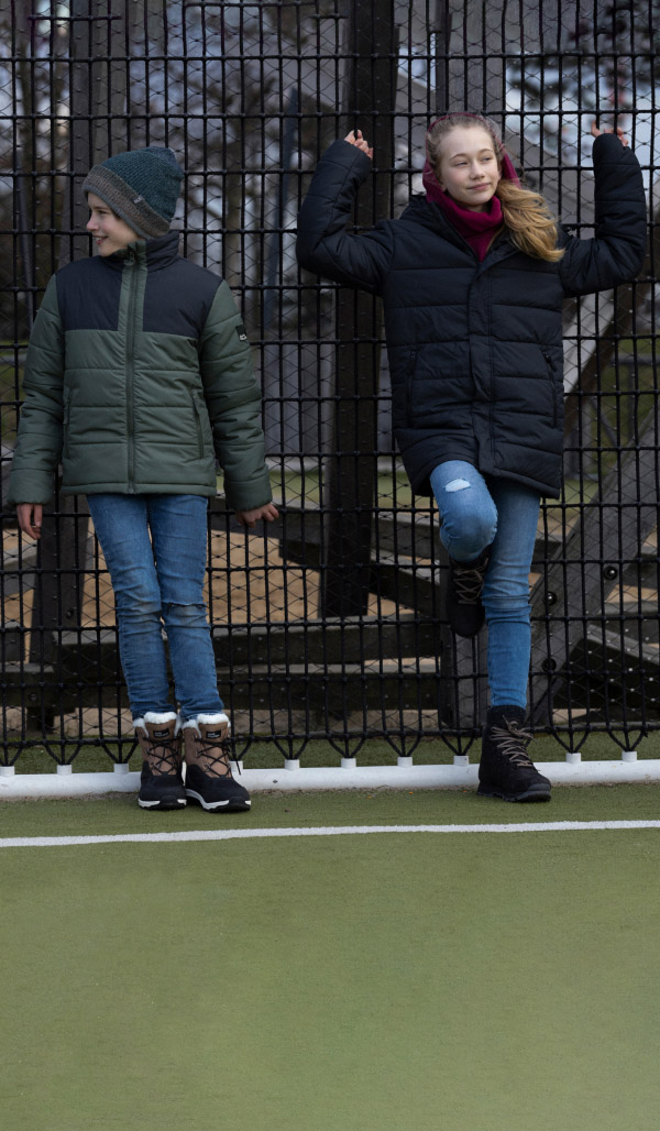 Fille et garçon adossés à la clôture