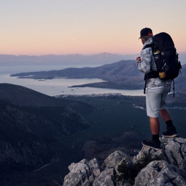Homme en train de randonner avec coucher de soleil