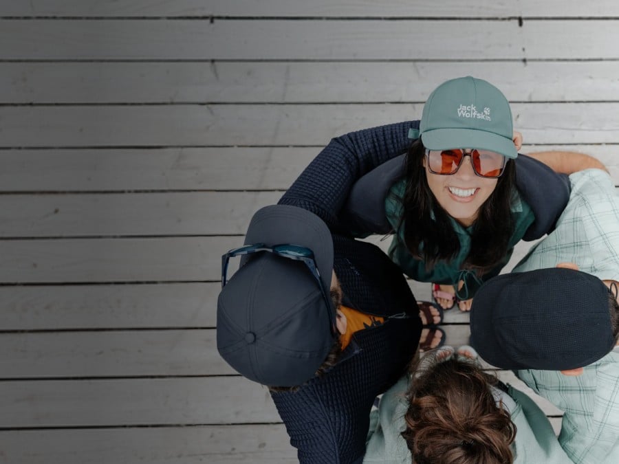 Deux luges transportant chacune deux personnes descendent une piste enneigée.&nbsp;Les personnes rient et portent des vêtements d’hiver, des bonnets et des lunettes de&nbsp;soleil&thinsp;; en arrière-plan, des montagnes&nbsp;enneigées.
