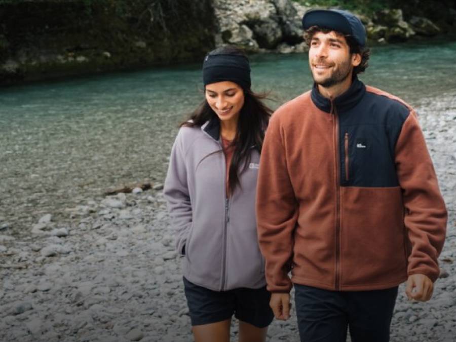 Deux jeunes adultes en vestes polaires sportives devant un lac